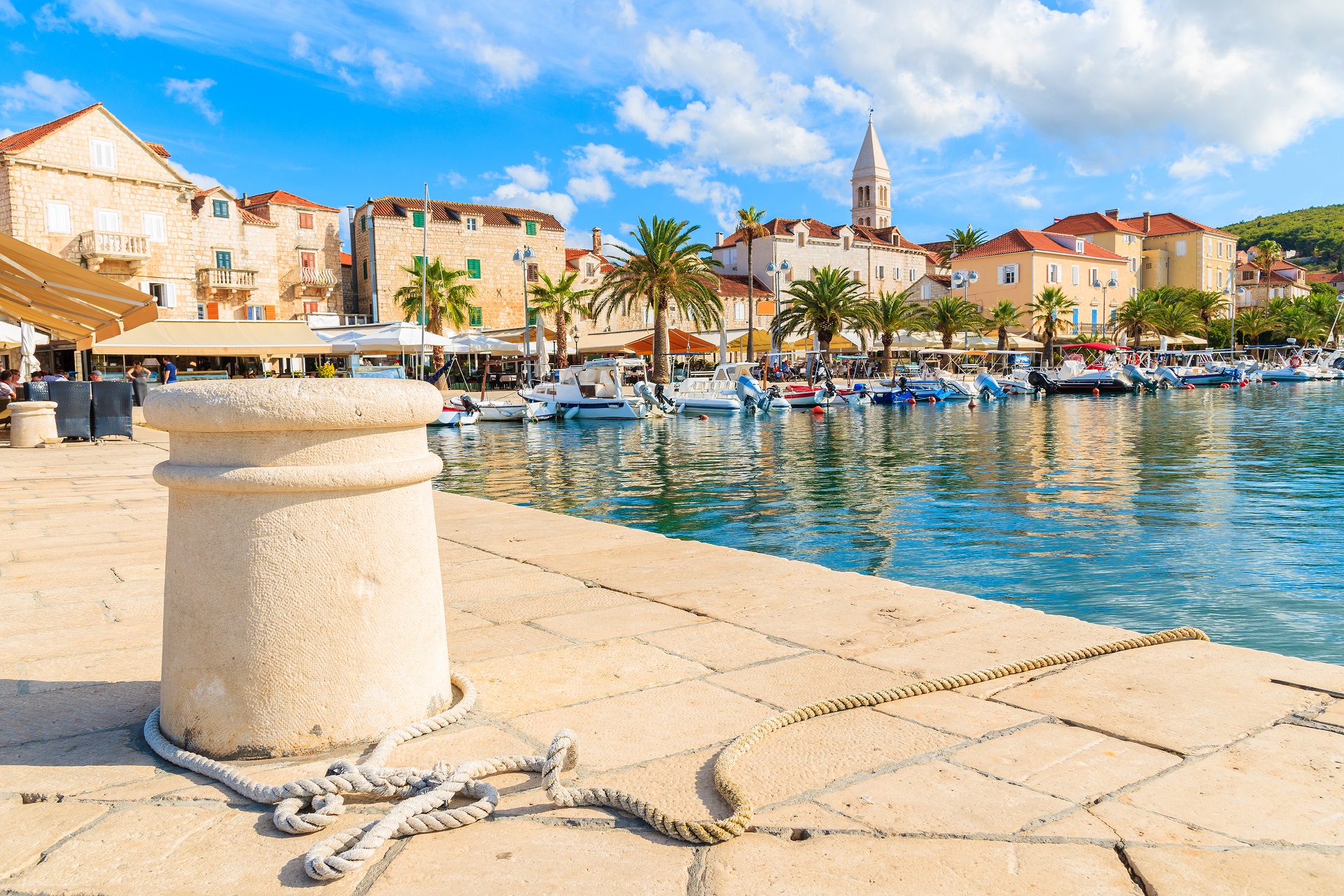 93136347 - pier in supetar port with colorful houses and boats, brac island, croatia